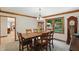 Bright dining room featuring a wooden table, six chairs, and a bay window with green views at 10418 Forest Creek Dr, Indianapolis, IN 46239