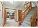 Open foyer view showcasing a staircase and an open doorway leading to a home office with built-in shelves at 10418 Forest Creek Dr, Indianapolis, IN 46239