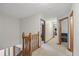 Upstairs hallway with carpet flooring and wooden railing leading to bedrooms, and great natural light at 10418 Forest Creek Dr, Indianapolis, IN 46239
