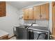 Well-equipped laundry room with modern washer and dryer, complemented by wooden cabinetry for storage at 10418 Forest Creek Dr, Indianapolis, IN 46239