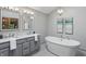 Elegant bathroom features double vanity sinks and a soaking tub, complete with modern fixtures and decor at 10418 Forest Creek Dr, Indianapolis, IN 46239