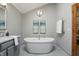 Luxurious main bathroom with a standalone tub, chandelier, and a vanity with a white countertop at 10418 Forest Creek Dr, Indianapolis, IN 46239