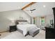 Spacious main bedroom boasts a vaulted ceiling with wood beam, ceiling fan, and a cozy sitting area at 10418 Forest Creek Dr, Indianapolis, IN 46239