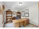 Comfortable home office featuring built-in bookshelves, a large desk, and natural light from a window at 10418 Forest Creek Dr, Indianapolis, IN 46239
