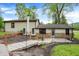 Backyard view with stone landscape wall and wooden foot bridge to the home's back entrance at 10972 W Old Nashville Rd, Columbus, IN 47201