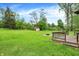 Expansive backyard featuring a fire pit, wooden deck, lush lawn, and convenient storage shed at 10972 W Old Nashville Rd, Columbus, IN 47201