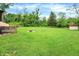 Open backyard with fire pit and storage shed, offering ample space for outdoor enjoyment and activities at 10972 W Old Nashville Rd, Columbus, IN 47201