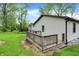 Home exterior showcases a wood deck set in a spacious green yard and natural surroundings at 10972 W Old Nashville Rd, Columbus, IN 47201