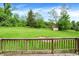 Large backyard with a fire pit, green grass, storage shed, and a view from the wooden deck at 10972 W Old Nashville Rd, Columbus, IN 47201