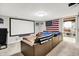 Recreation room features a projector screen, comfortable seating, and entertainment accessories in the finished basement at 10972 W Old Nashville Rd, Columbus, IN 47201