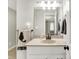 Bathroom features a light vanity with stone countertop, decorative mirror, light fixtures, and a towel rack at 10972 W Old Nashville Rd, Columbus, IN 47201