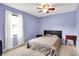 Bedroom with blue walls, neutral carpet, and a window with white curtains for lots of natural light at 10972 W Old Nashville Rd, Columbus, IN 47201