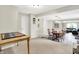 The dining area features a wood table, chandelier, and transitions into a living room with a sofa and natural light at 10972 W Old Nashville Rd, Columbus, IN 47201