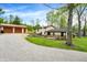 Charming home exterior with a spacious yard, detached garage, and gravel driveway at 10972 W Old Nashville Rd, Columbus, IN 47201
