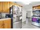 Galley kitchen featuring stainless steel appliances and warm wood cabinetry with modern fixtures and bright lighting at 10972 W Old Nashville Rd, Columbus, IN 47201