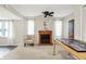 Living room featuring a decorative fireplace, mantel, and a comfortable chair bathed in natural light from the windows at 10972 W Old Nashville Rd, Columbus, IN 47201