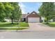 Charming brick home with a two-car garage, a well-manicured lawn, and mature trees in a quiet neighborhood at 11209 Black Gold Dr, Noblesville, IN 46060