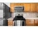 Modern kitchen features stainless steel microwave, stove, oven, and natural wood cabinets at 11209 Black Gold Dr, Noblesville, IN 46060