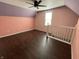 Charming bedroom with wood-look floors, a ceiling fan, and a bright window at 1164 Groff Ave, Indianapolis, IN 46222
