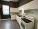 Traditional kitchen features white cabinets, appliances, and worn vinyl flooring at 1164 Groff Ave, Indianapolis, IN 46222