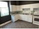 Traditional kitchen features white cabinets, appliances, and worn vinyl flooring at 1164 Groff Ave, Indianapolis, IN 46222