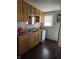 Compact kitchen features wooden cabinets, and essential appliances, and a tile backsplash at 1168 N Gladstone Ave, Indianapolis, IN 46201