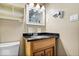 Bathroom featuring a wooden vanity with a black countertop and a white toilet at 1170 N Concord St, Indianapolis, IN 46222