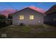 Exterior of home at dusk with gray siding, white framed windows and landscaping at 1170 N Concord St, Indianapolis, IN 46222