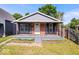 Bungalow featuring brick facade, gray siding, front porch, and well-maintained lawn at 1170 N Concord St, Indianapolis, IN 46222