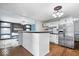This eat-in kitchen features stainless steel appliances, white cabinetry, a breakfast bar and a modern light fixture at 1170 N Concord St, Indianapolis, IN 46222
