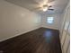 Bright bedroom featuring dark wood floors, white walls, ceiling fan, and a window at 1263 Barefoot Trl, Greenwood, IN 46142