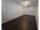 Bedroom featuring dark wood floors, fan, closet with folding doors, and door at 1263 Barefoot Trl, Greenwood, IN 46142
