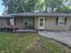 Inviting front porch with brick accents and seating area with mature landscaping at 1263 Barefoot Trl, Greenwood, IN 46142