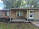 Inviting front porch with brick accents and seating area with mature landscaping at 1263 Barefoot Trl, Greenwood, IN 46142