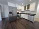 Modern kitchen featuring white cabinets, stainless steel appliances, and dark hardwood floors at 1263 Barefoot Trl, Greenwood, IN 46142