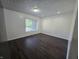 Living room with dark wood floors, white walls, textured ceiling, and a bright window at 1263 Barefoot Trl, Greenwood, IN 46142