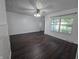 Bright living room featuring updated dark wood floors, white walls, and window with blinds at 1263 Barefoot Trl, Greenwood, IN 46142
