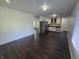 Open concept floorplan with living room, dining area, and kitchen featuring dark floors and white walls at 1263 Barefoot Trl, Greenwood, IN 46142