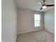 Neutral bedroom space with carpeted floors, a window for natural light, and a ceiling fan enhancing comfort and air circulation at 12878 Ari Ln, Fishers, IN 46037