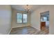 Bright dining room featuring wood-look floors, a chandelier, and a large window with natural light at 12878 Ari Ln, Fishers, IN 46037
