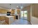 Open kitchen featuring an island, light wood cabinetry, modern appliances, and a sliding glass door at 12878 Ari Ln, Fishers, IN 46037