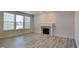 Bright living room with wood-look flooring, a fireplace, and large windows offering ample natural light at 12878 Ari Ln, Fishers, IN 46037