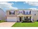 Charming two-story home with well-manicured lawn, lovely landscaping, covered front porch, and attached two-car garage at 12993 E 131St St, Fishers, IN 46037