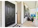 Inviting covered front porch with black door, modern welcome sign, and comfortable seating for enjoying the outdoors at 12993 E 131St St, Fishers, IN 46037