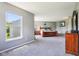 Large main bedroom boasts big windows, neutral tones, a wood frame bed and dresser at 12993 E 131St St, Fishers, IN 46037