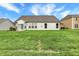 Spacious backyard with well-maintained lawn and a view of the house exterior with white siding and trim at 1334 Sunnybrook Ln, Greenwood, IN 46143