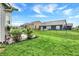 Landscaped backyard featuring green grass, flowering bushes and a view of neighborhood houses on a bright day at 1334 Sunnybrook Ln, Greenwood, IN 46143