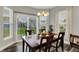 Bright dining room with backyard views through sliding glass doors and two windows; wood-look flooring at 1334 Sunnybrook Ln, Greenwood, IN 46143
