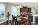 Sunlit dining room with views to the kitchen, backyard, and dark-stained hardwood floors at 1334 Sunnybrook Ln, Greenwood, IN 46143