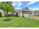 Beautifully landscaped front yard featuring a healthy green lawn, decorative trees, and a three car garage at 1334 Sunnybrook Ln, Greenwood, IN 46143